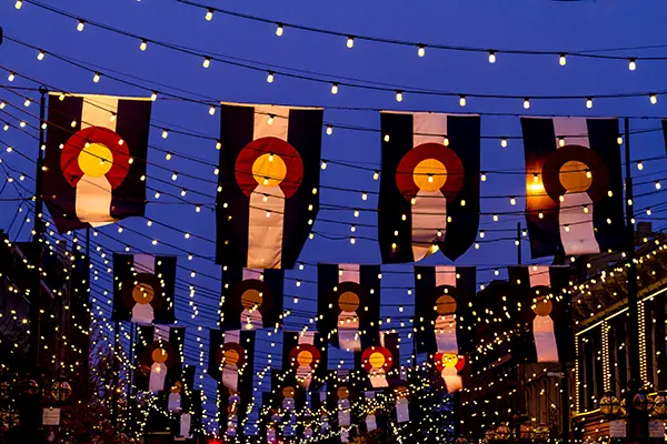 Colorado flags hanging over a street at night